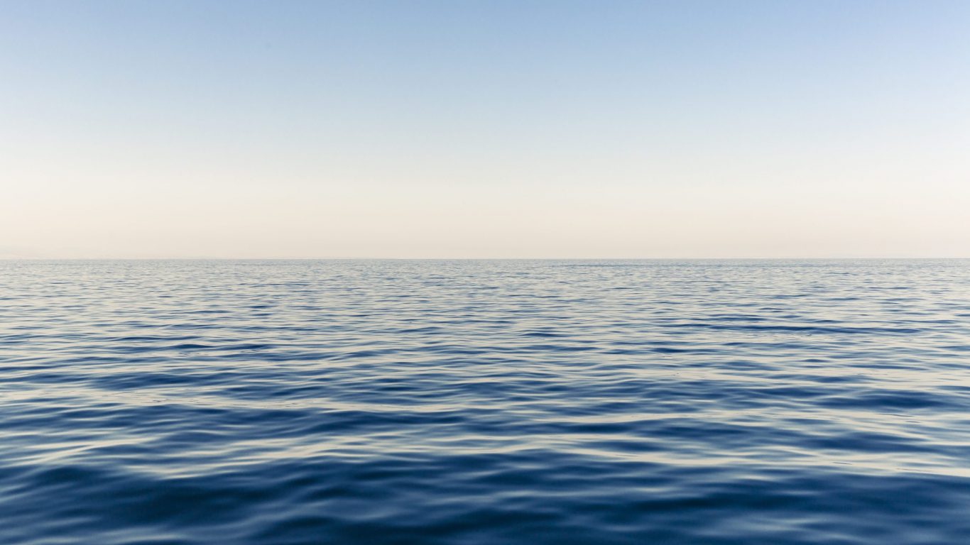 Foto van een kalme zee in zwak zonlicht op slowcialmedia waarbij je gefocust kunt werken